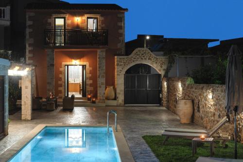 uma villa com piscina em frente a uma casa em Villa Eliomylos em Suda