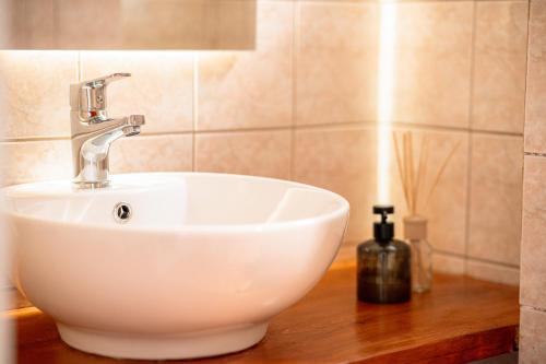 a white sink on a wooden counter in a bathroom at A&D Houses No3 in Patra