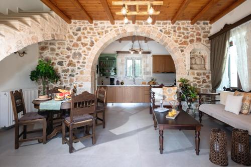 una cucina e un soggiorno con parete in pietra di Villa Eliomylos a Souda (Suda)