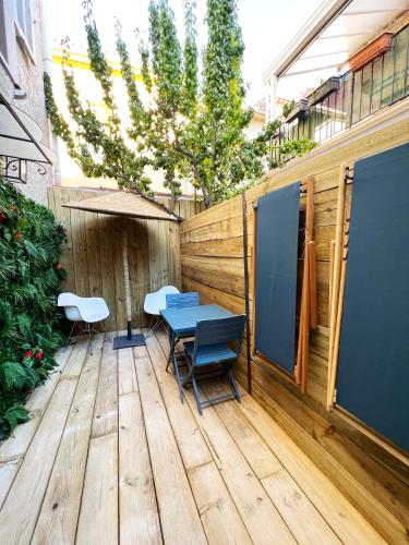 une terrasse en bois avec une table et des chaises. dans l'établissement LE GRAND PECHEUR DE CASSIS, à Cassis