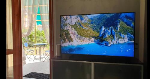 una TV a schermo piatto seduta sopra un armadio di Desiree Paradis a Loano