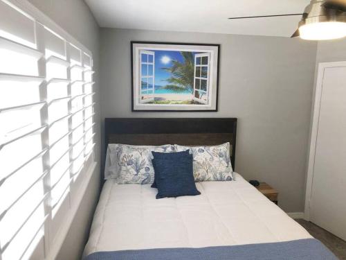 a bedroom with a bed with a picture on the wall at Modern Apartment - 1 of 4 in Punta Gorda
