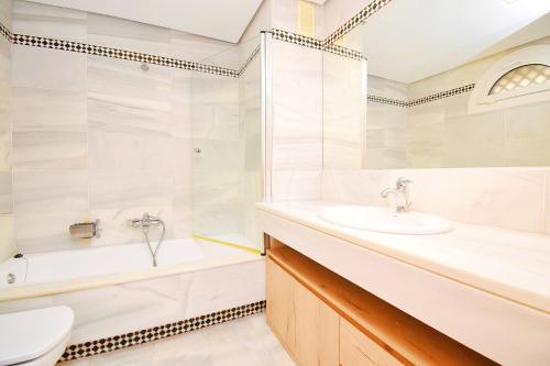 ein Badezimmer mit einem Waschbecken, einer Badewanne und einem WC in der Unterkunft Expoholidays - Galeon 46 Puerto Deportivo Almerimar in Almerimar