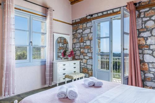 Un dormitorio con una cama y una ventana grande en ALTHEA, en Panormos Skopelos