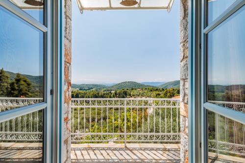 a room with a view of the mountains through windows at Althea in Panormos Skopelos