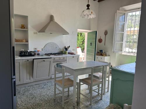a kitchen with a table and a table and chairs at Villa Sant'Antonio con ampio giardino a due passi dal mare in SantʼAnna