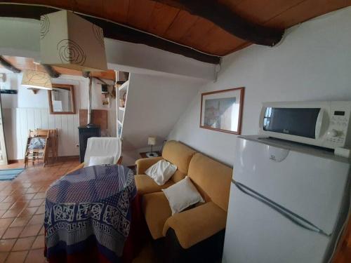 een woonkamer met een bank en een magnetron bij La Casa Chica de Luis in Fuenteheridos