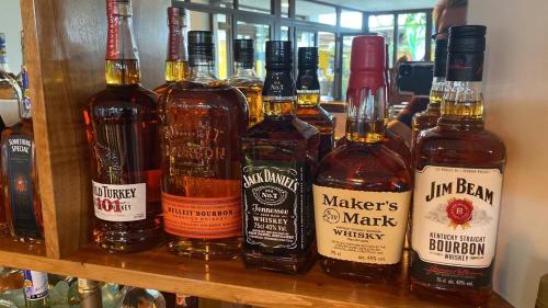 a bunch of bottles of alcohol sitting on a shelf at Hotel La Isla in Puerto Ayora