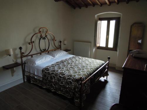 ein Schlafzimmer mit einem Bett in einem Zimmer mit einem Fenster in der Unterkunft La Turra - Casa di Campagna in Greve in Chianti
