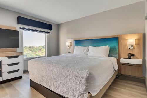 a bedroom with a large bed and a large window at Holiday Inn Express & Suites Destin - Miramar Beach by IHG in Destin
