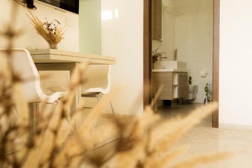 Habitación con 2 sillas blancas y lavamanos en Casale alle Vigne, en Nardò