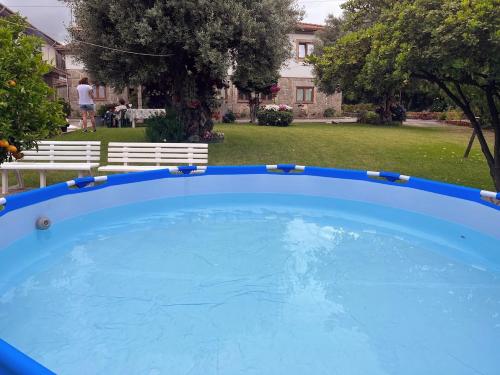 a large blue swimming pool in a yard at Quintinha d´Avó in Vila de Prado