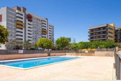 an empty swimming pool with buildings in the background at Vacaciones perfectas. in Paterna