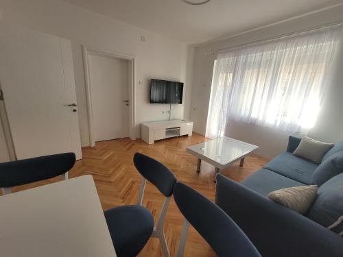 a living room with a blue couch and a table at Happy apartment Strumica 2 in Strumica