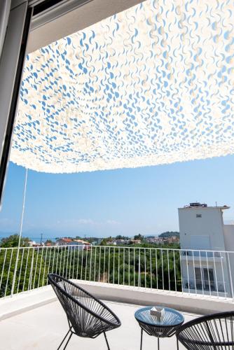 a view from a balcony with two chairs and a window at Ennea Suites-Null suite in Flámbouras