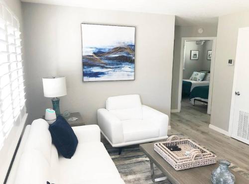 a living room with a white couch and a chair at Modern Apartment - 2 of 4 in Punta Gorda