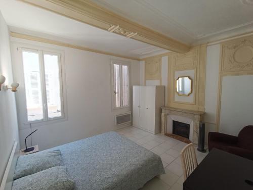 biały pokój z łóżkiem i lodówką w obiekcie Appartements et studio rénovés en 2022, Intra Muros Avignon w Awinionie