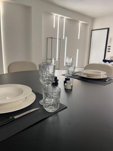 瑪格麗塔薩沃亞的住宿－Casa Mare Design，一张黑桌,上面有盘子和玻璃杯