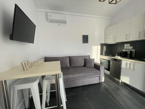 een kleine woonkamer met een bank en een keuken bij Villa Μyrtali in Meganisi