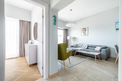 a living room with a couch and a table at Apartament Słoneczny Bulwar Ustka in Ustka