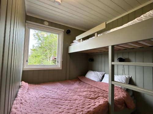 - une chambre avec des lits superposés et une fenêtre dans l'établissement Vegglihytta - cabin with a tranquil location, à Veggli