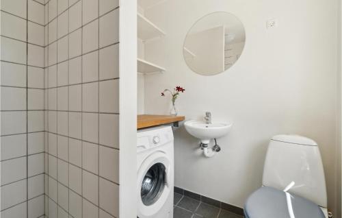 a bathroom with a washing machine and a sink at Nice Apartment In Aakirkeby With Wifi in Åkirkeby