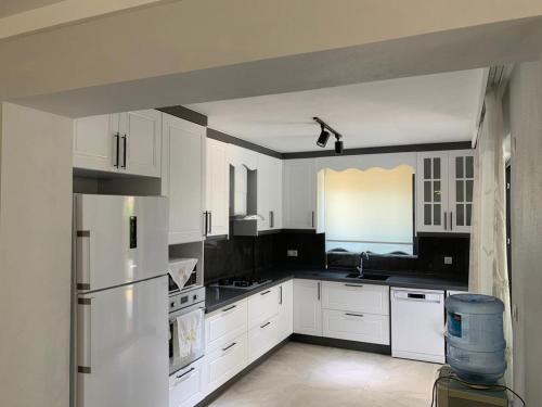 a kitchen with white cabinets and a white refrigerator at Villa’s Tomris in Ortaca