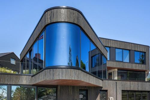 un bâtiment de bureau avec une grande façade en verre dans l'établissement Madla.Villa, à Stavanger