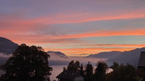 a view of a sunset with a house in the foreground at B&B Haussener in Krattigen