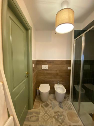 a bathroom with a toilet and a sink and a green door at A Casa del Console apartment in Manfredonia
