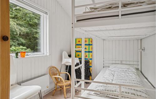 ein kleines Schlafzimmer mit einem Etagenbett und einem Fenster in der Unterkunft Strandbo in Thyholm