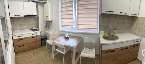 a small kitchen with a table and a sink at Dream Accommodation in Chiajna