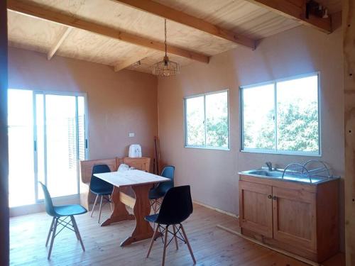 a kitchen with a table and chairs in a room at Cabañas Guanaqueros Arriendo Diario in Guanaqueros