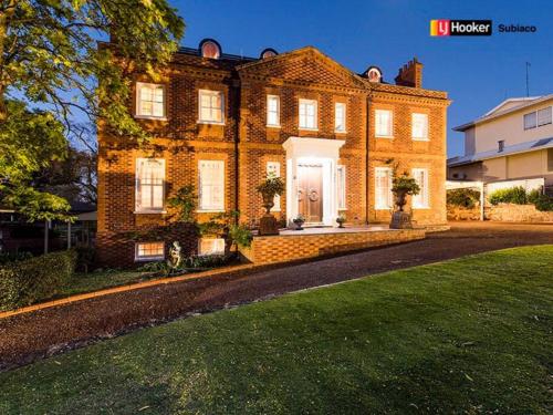 a large brick house with a white front door at Luxury Cottage at the Manor on the River!!! in Bicton