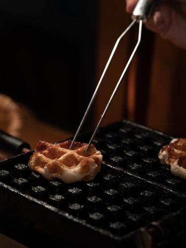 a person is making waffles on a grill at Enzian Inn in Leavenworth