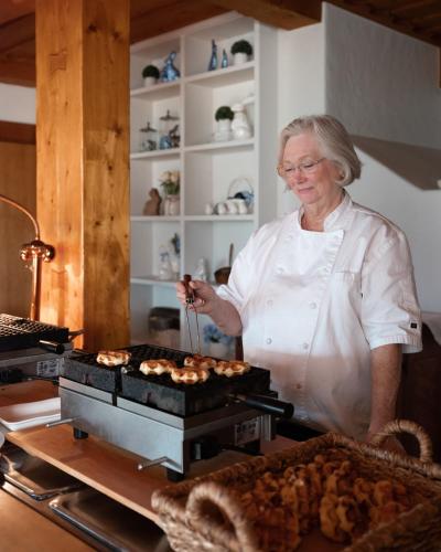 a woman standing in a kitchen preparing food at Enzian Inn in Leavenworth