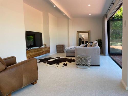 a living room with a couch and a tv at Luxury Cottage at the Manor on the River!!! in Bicton
