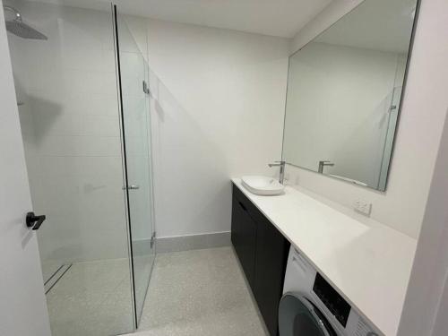 y baño con ducha, lavabo y lavadora. en Luxury Cottage at the Manor on the River!!!, en Bicton