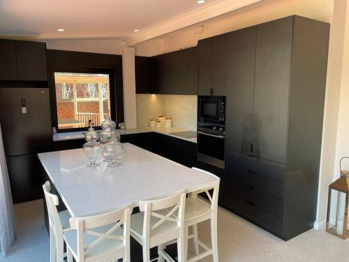 a kitchen with a white table and white chairs at Luxury Cottage at the Manor on the River!!! in Bicton