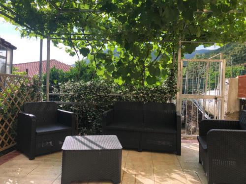 patio con sedie nere e tavoli sotto un albero di La Strettoia a Caprioli
