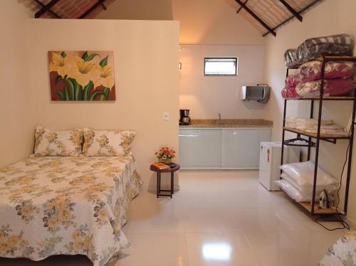 a bedroom with a bed and a sink in a room at Chalés Pôr Do Sol in Alto Caparao