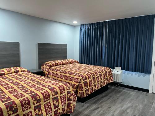 a hotel room with two beds and curtains at Travel Inn Gilroy in Gilroy