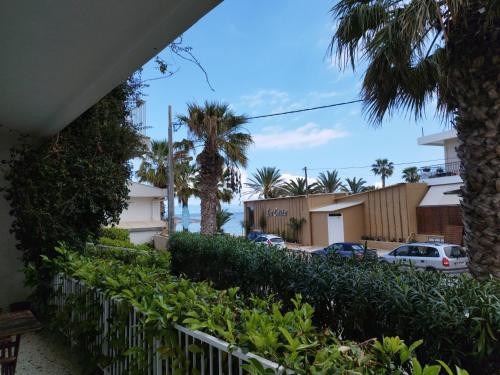 - une vue depuis le balcon d'une maison avec des palmiers dans l'établissement TIKI BEACH STUDIOS, à Nea Makri