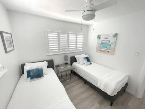 two beds in a small room with white walls at Modern Apartment - 4 of 4 in Punta Gorda