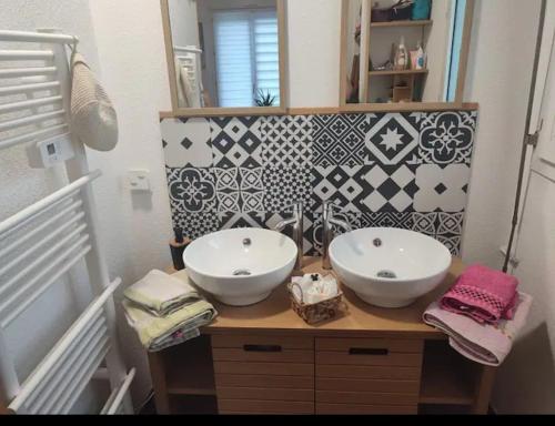 a bathroom with two white sinks on a wooden counter at Maison au calme proche centre ville in Le Mans