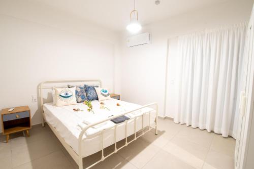 Habitación blanca con cama y ventana en Ennea suites-Storm suite, en Flámbouras