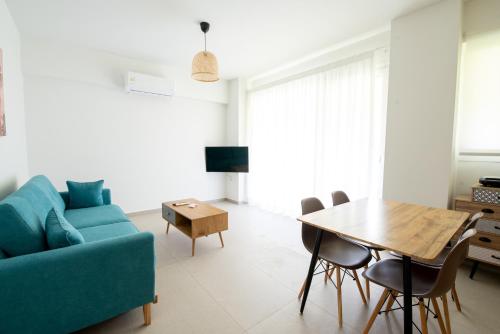 uma sala de estar com um sofá azul e uma mesa em Ennea suites-Storm suite em Flámbouras