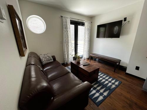 a living room with a leather couch and a table at Hotel Frisco in Frisco