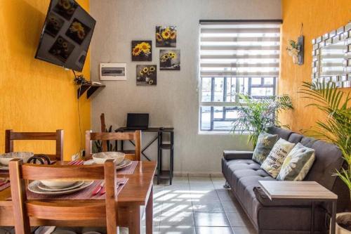 a living room with a couch and a table at Casa Girasol Tulum in Tulum