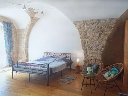 una camera da letto con un letto e due sedie di Pour les amoureux des vieilles pierres a Poussan